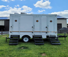 Toilet rental service truck in New York and purple porta potty