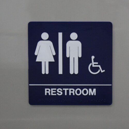 Placard denotes wheelchair accessible restroom entrance.