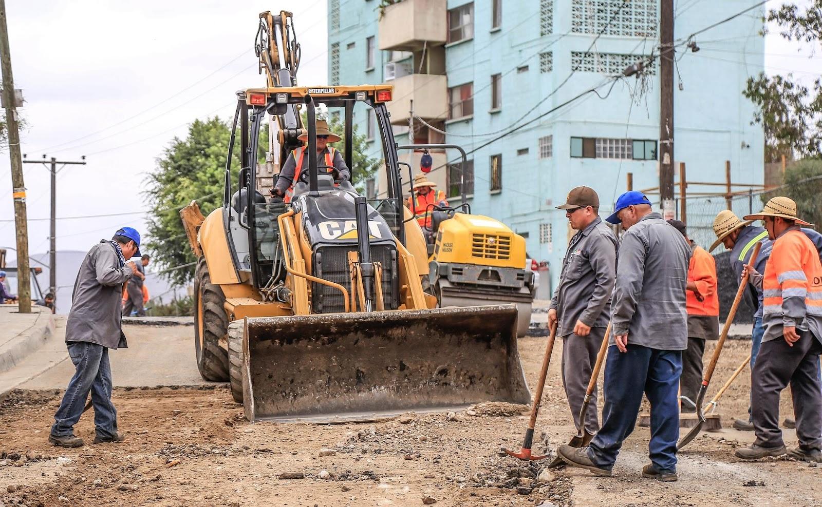 workers and construction vehicles at road building site